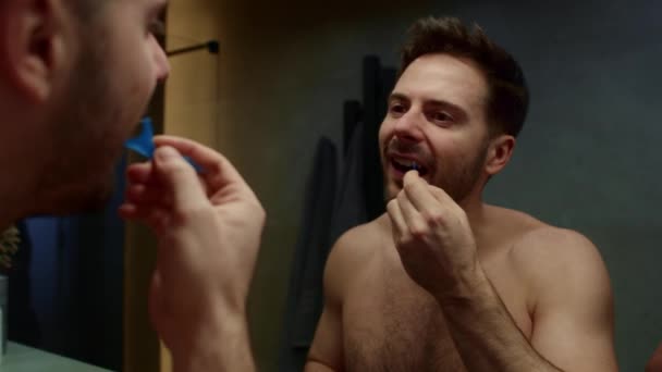 Человек с зубной нитью в ванной комнате - Кадры, видео