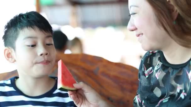 Szczęśliwy Asian dziecko z matka cieszyć się jedzenie dojrzały arbuz . - Materiał filmowy, wideo
