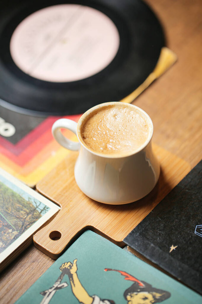 Una tazza di caffè si trova sopra un tavolo di legno. - Foto, immagini