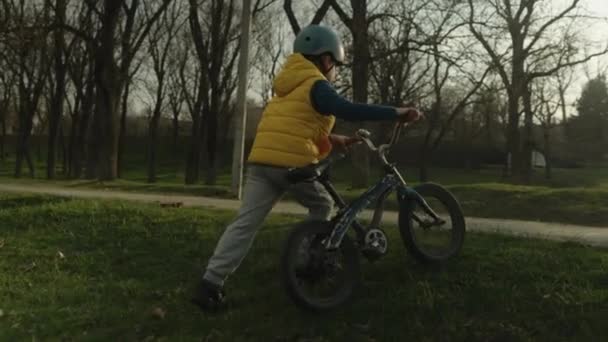 Mały chłopiec jeżdżący na rowerze w kasku. Kid jazdy rowery w przyrodzie. - Materiał filmowy, wideo