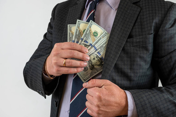 Jeune travailleur d'affaires montrent dollars dans la main isolé sur gris, comptage des finances - Photo, image
