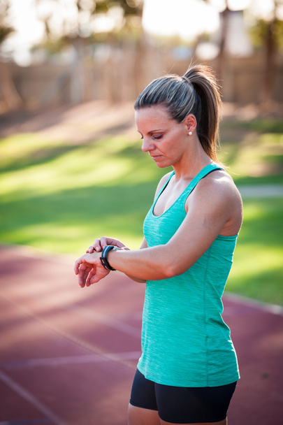 afbeelding van een vrouwelijke atleet aanpassen haar hartslagmeter - Foto, afbeelding