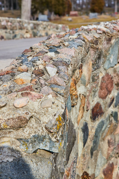 Détail d'un mur de pierre rustique dans le cimetière Lindenwood, Fort Wayne, mettant en valeur les textures naturelles et l'artisanat dans un cadre de parc serein. - Photo, image