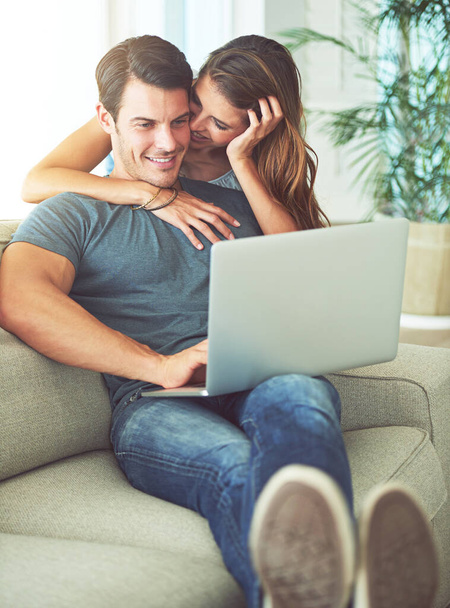 Laptop, συγκόλληση και γυναίκα αγκαλιάζει τον άνδρα σε καναπέ δικτύωση στα μέσα κοινωνικής δικτύωσης, την ιστοσελίδα ή το διαδίκτυο. Ευτυχισμένος, αγάπη και θηλυκό πρόσωπο αγκαλιάζει σύζυγο ανάγνωση σε απευθείας σύνδεση blog με υπολογιστή στο σαλόνι στο σπίτι. - Φωτογραφία, εικόνα