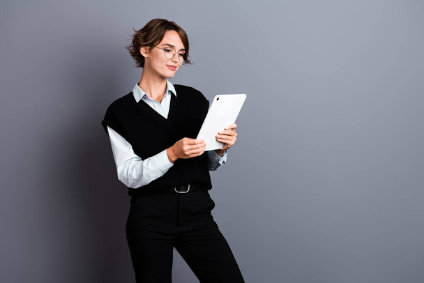Photo of stunning confident lady wear stylish clothes reading report modern ipad gadget empty space isolated on gray color background. - Fotoğraf, Görsel