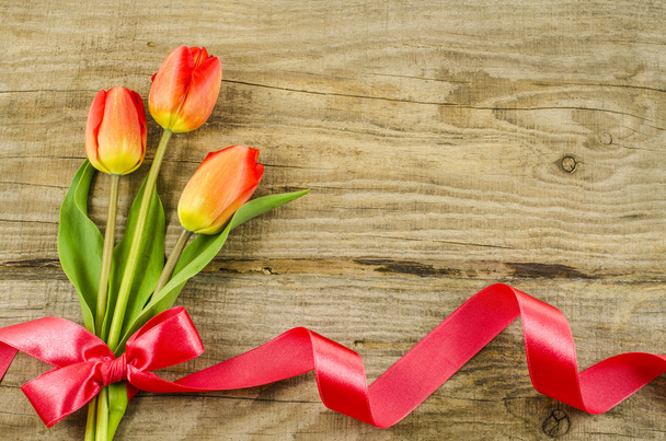 Empty wooden background with colorful flowers and red ribbon - Foto, imagen