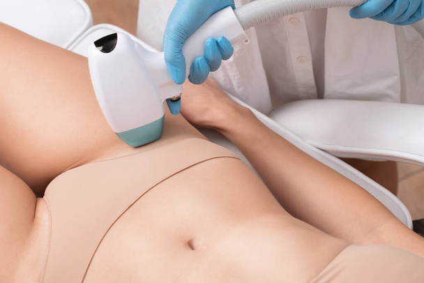 epilaatio karvojen poisto menettely naisten kehon. Kosmetologi tekee lasernuorennusleikkausta kauneushoitolassa. Poistan ei-toivottuja karvoja. Laitteisto ipl kosmetiikka - Valokuva, kuva