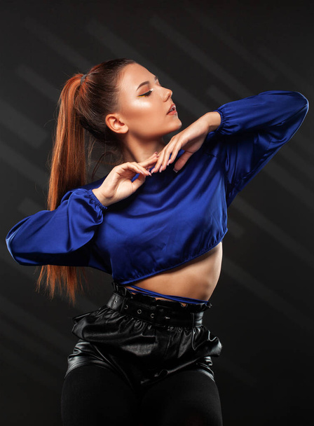 Portrait of attractive girl with healthy clean skin and beautiful make-up. She is wearing a blue blouse and a black leather skirt. - Foto, Bild