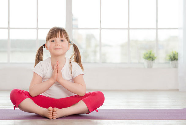 Smiling little girl in lotus position - Photo, Image