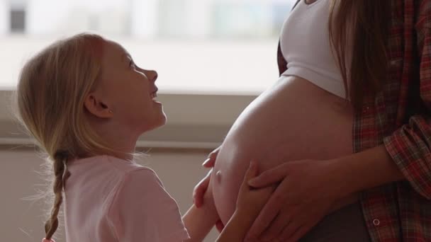 niña preescolar abraza a la madre embarazada - Metraje, vídeo