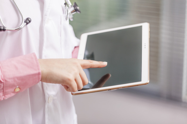 Женщина-врач держит цифровой планшет
  - Фото, изображение