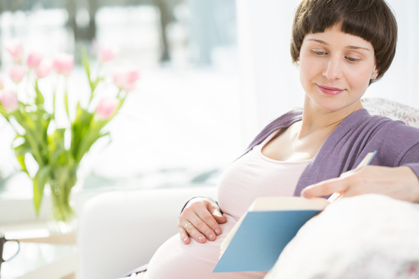 Pregnant woman reading book - 写真・画像