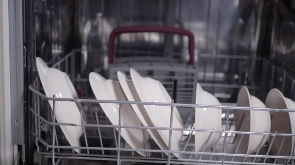 Молода жінка відкриває чистий білий посуд - Кадри, відео