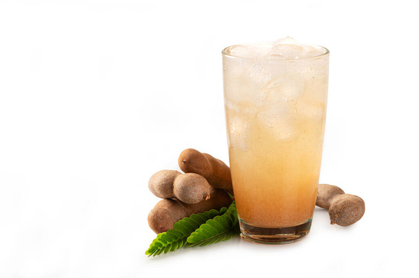 Свежий тамаринский сок с тамариндой и листья на белом фоне - Фото, изображение
