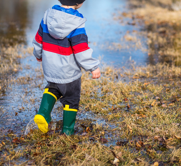 水たまりを歩く少年 - 写真・画像