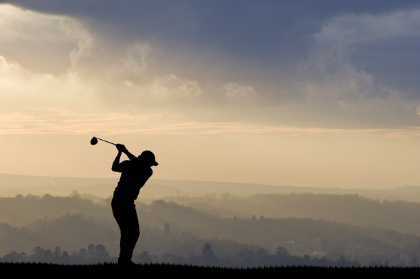 golfer silhouet tegen verbluffende avondrood - Foto, afbeelding