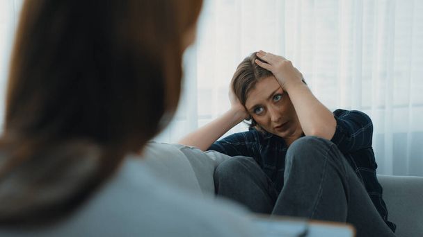 Sad PTSD woman patient in therapy for mental health with psychologist, depression or grief after life failure. Frustrated trauma young woman talking to prim psychologist about emotion in clinic - Photo, Image