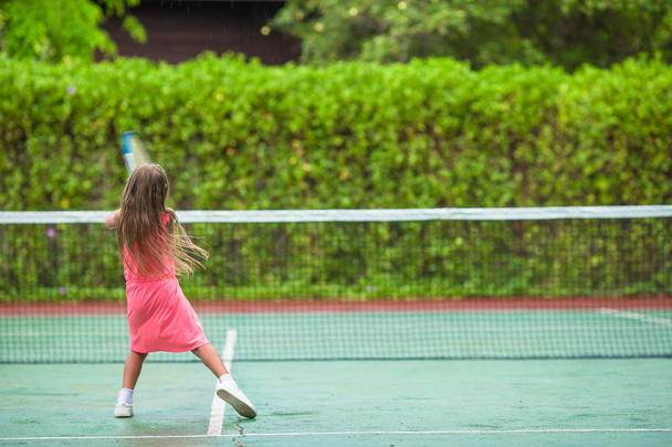 Malá holčička hrát tenis na kurtech - Fotografie, Obrázek