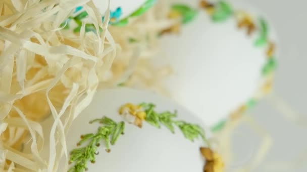 Húsvét három gyönyörű hímzett tojások tojáshéj szalagok fészekben csomagolópapír fehér háttér szöveges gratuláció találkozó családi dekoráció otthon dekoráció ajándék szállítás - Felvétel, videó