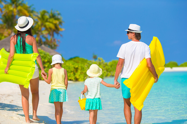 Молодая семья из четырех человек на пляжном отдыхе
 - Фото, изображение