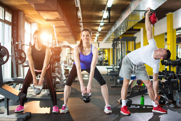 Grupo de deportistas haciendo ejercicios con pesas en el gimnasio - Foto, Imagen