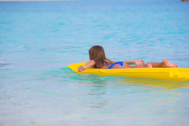 Чарівна маленька дівчинка на повітрі надувний матрац у морі
 - Фото, зображення