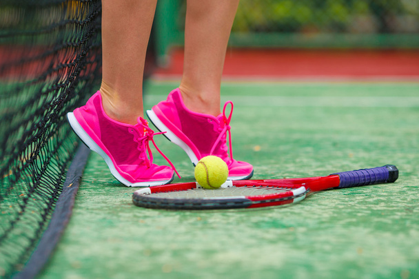 Κοντινό πλάνο πάνινα παπούτσια κοντά στην ρακέτα του τένις και μπάλα - Φωτογραφία, εικόνα