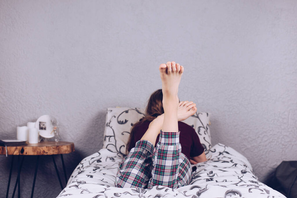 10代の女の子のベアフィート. パジャマの少女は毛布で覆われたベッドの上に横たわっている. フット&ヒール - 写真・画像