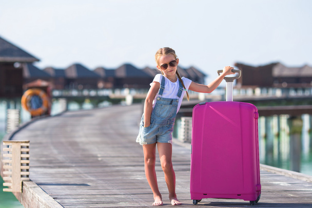 kleines entzückendes Mädchen mit großem Gepäck im Sommerurlaub - Foto, Bild