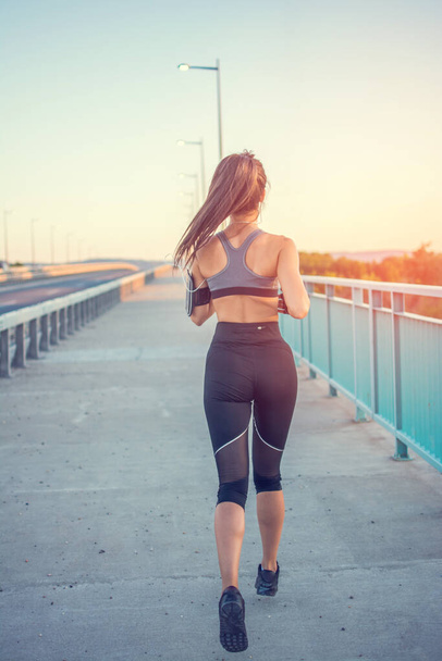 Köprüde koşan sportif kızın arka görüntüsü - Fotoğraf, Görsel