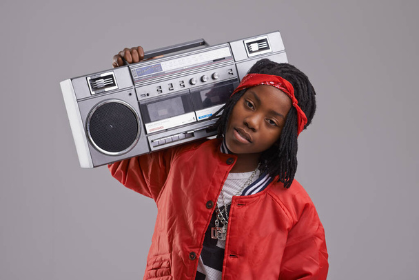 Kind, Hip Hop und Porträt mit Radio für Rap-Musik und Tanz in einem Studio mit urbaner Kleidung. Mode, afrikanisches Kind und Boombox mit trendiger Kleidung und jugendlichem Swag mit Selbstbewusstsein und grauem Hintergrund. - Foto, Bild