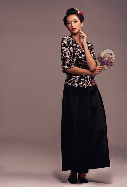 Retrato, mulher asiática e moda com espelho de mão em confiança no estúdio em fundo marrom no estilo tradicional e elegante. Japonês, pessoa feminina e roupas de grife com roupa - Foto, Imagem