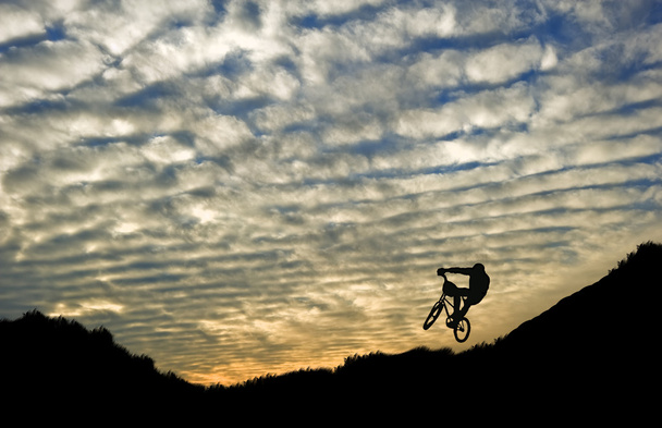 見事な夕日に対して極端なスポーツ バイク乗馬シルエット - 写真・画像