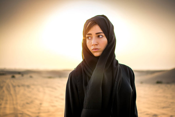Portrait of beautiful Arab woman in the desert during sunset - Photo, Image