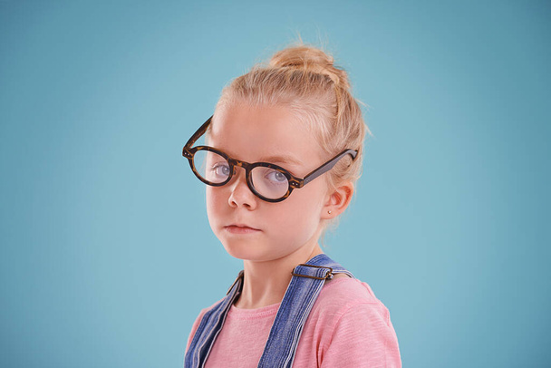 Çocuk, portre ve gözlük vizyonu, gençlik gelişimi için optometri sağlık hizmetleri, mavi arka plan veya maket alanı için stüdyoda. Gözlük çerçevesi, görüş veya lens için kadın, çocuk ve göz giysisi. - Fotoğraf, Görsel