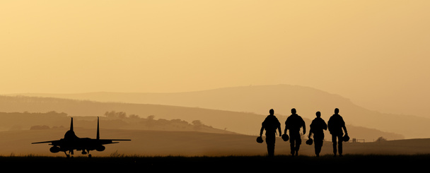 silhouet van militaire aanval vliegtuigen tegen levendige zonsondergang sk - Foto, afbeelding