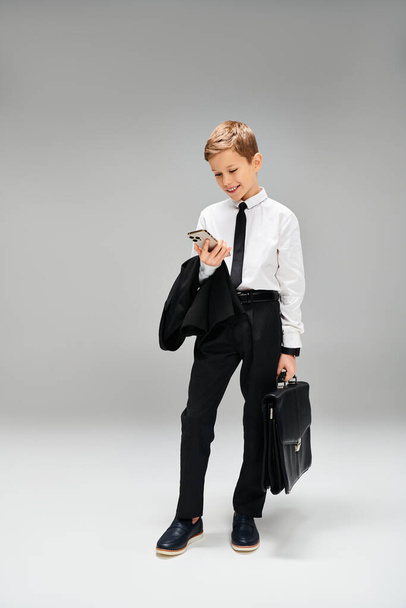 Preadolescente jongen in pak en das met een aktetas. - Foto, afbeelding