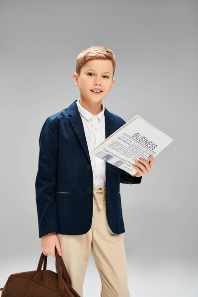 A stylish young boy holding a briefcase and a paper. - Photo, Image