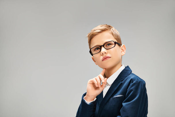 Young man in glasses and blue jacket on gray backdrop. - Photo, Image