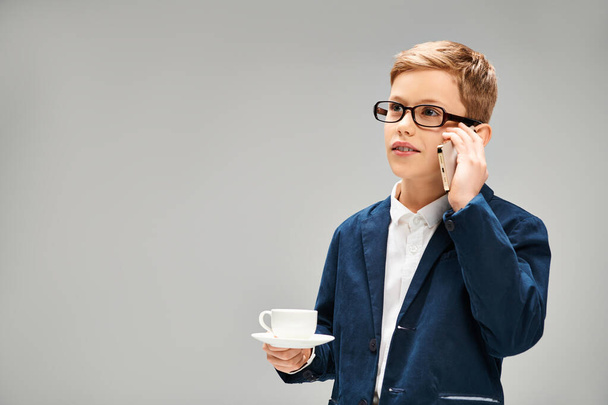 Préadolescent garçon en costume et lunettes parler sur téléphone portable. - Photo, image