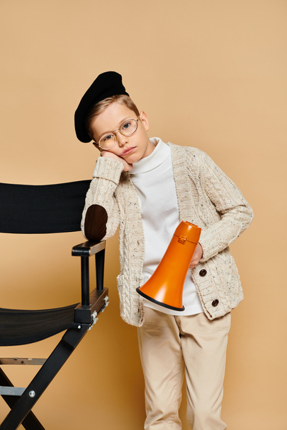 Niño preescolar vestido como director de cine sostiene un megáfono. - Foto, imagen