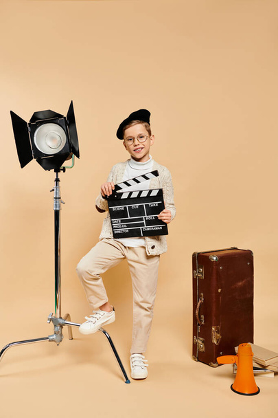 A boy directs a film scene with a clapper in front of a camera. - Photo, Image