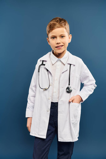 Εφηβικό αγόρι με λευκό παλτό και στηθοσκόπιο σε μπλε φόντο. - Φωτογραφία, εικόνα