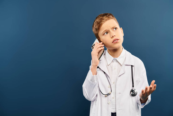 Um menino pré-adolescente de casaco branco, segurando um estetoscópio, procurando pronto para ajudar. - Foto, Imagem