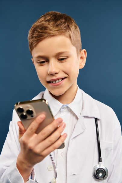 Niño en blanco médicos abrigo sostiene el teléfono celular. - Foto, imagen