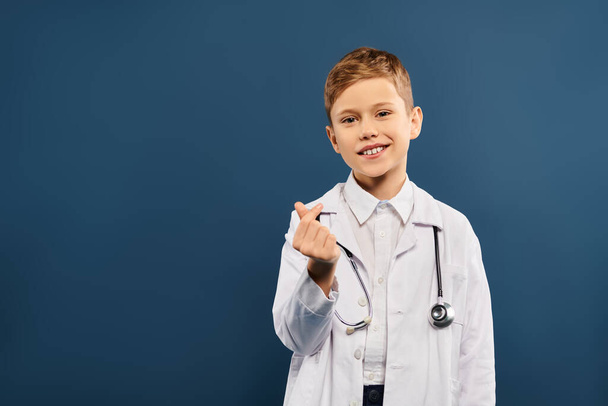 Ein frühpubertärer Junge im weißen Laborkittel mit einem Stethoskop in der Hand. - Foto, Bild