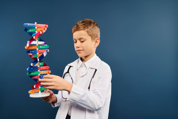 Предрожденный мальчик, одетый как врач, держит сложную модель структуры. - Фото, изображение