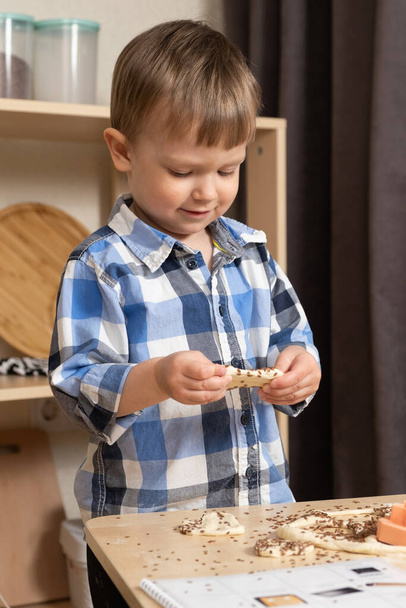 Mały chłopiec robi ciasteczka z bezglutenowego zdrowego ciasta z nasionami lnu - Zdjęcie, obraz
