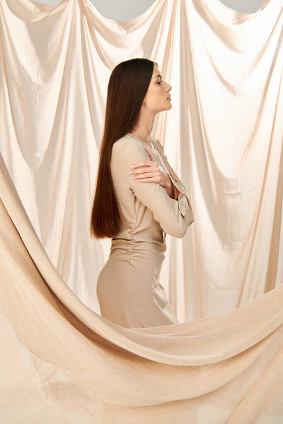 Een jonge vrouw met lang brunette haar poseren in een zomer outfit in een studio setting, gevangen in een moment uitstralen van een zomerse stemming. - Foto, afbeelding