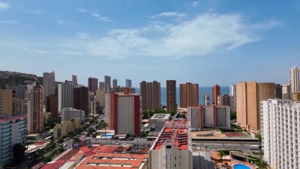 Letecký pohled na město Benidorm, Španělsko. Pohled na ulice, hotely a mrakodrapy směrem k moři z 18. patra budovy, letní slunný den.Vysoce kvalitní FullHD záběry - Záběry, video